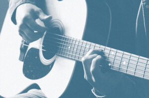 Photo of a man playing an acoustic guitar.