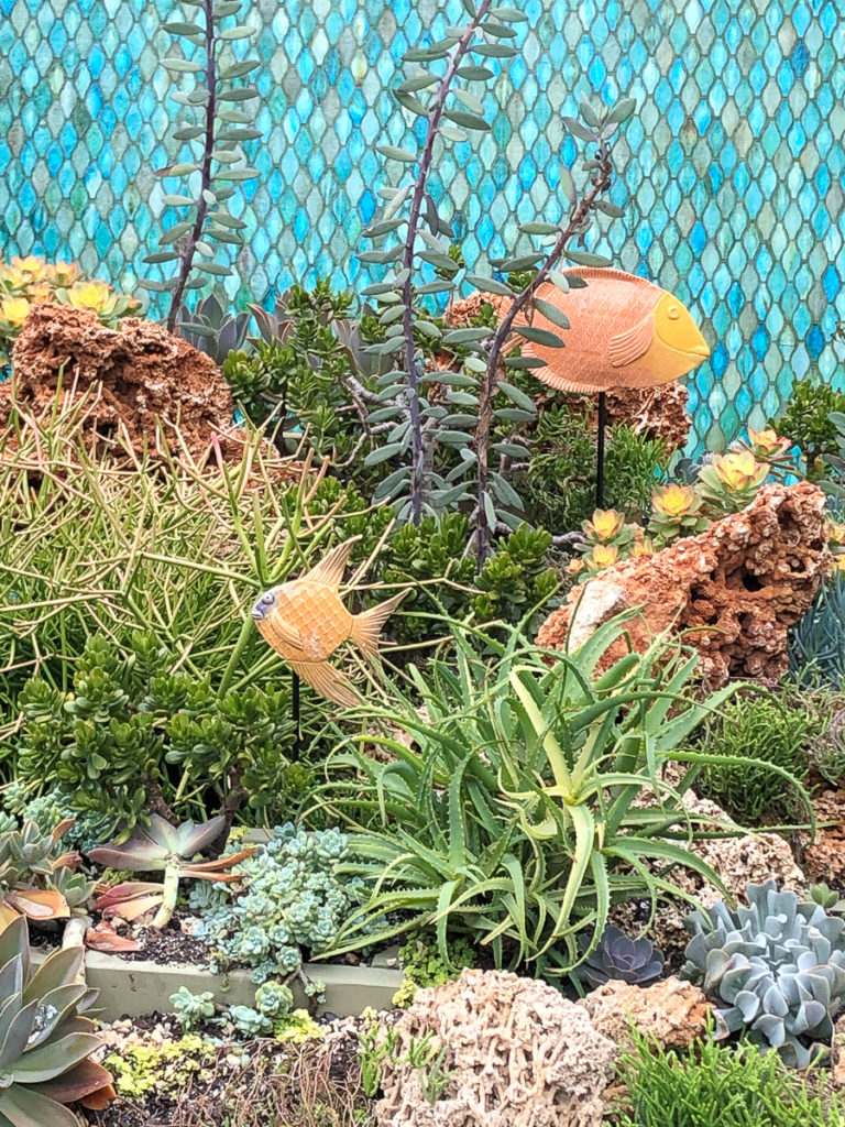 A close-up of one of the Smithsonian garden displays where the plants have been chosen and arranged to look like an under-sea coral reef, including metal fish sculptures.