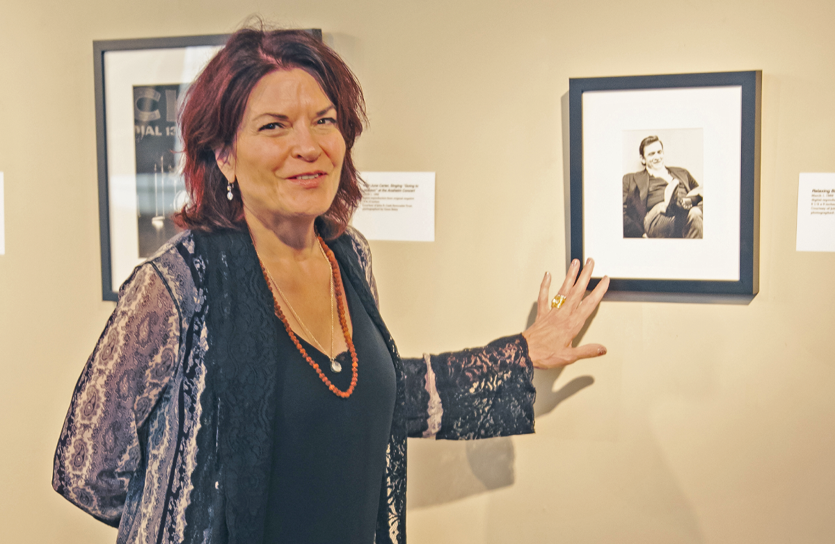 Rosanne Cash posing next to one of her favorite images of her late father, Johnny Cash. 